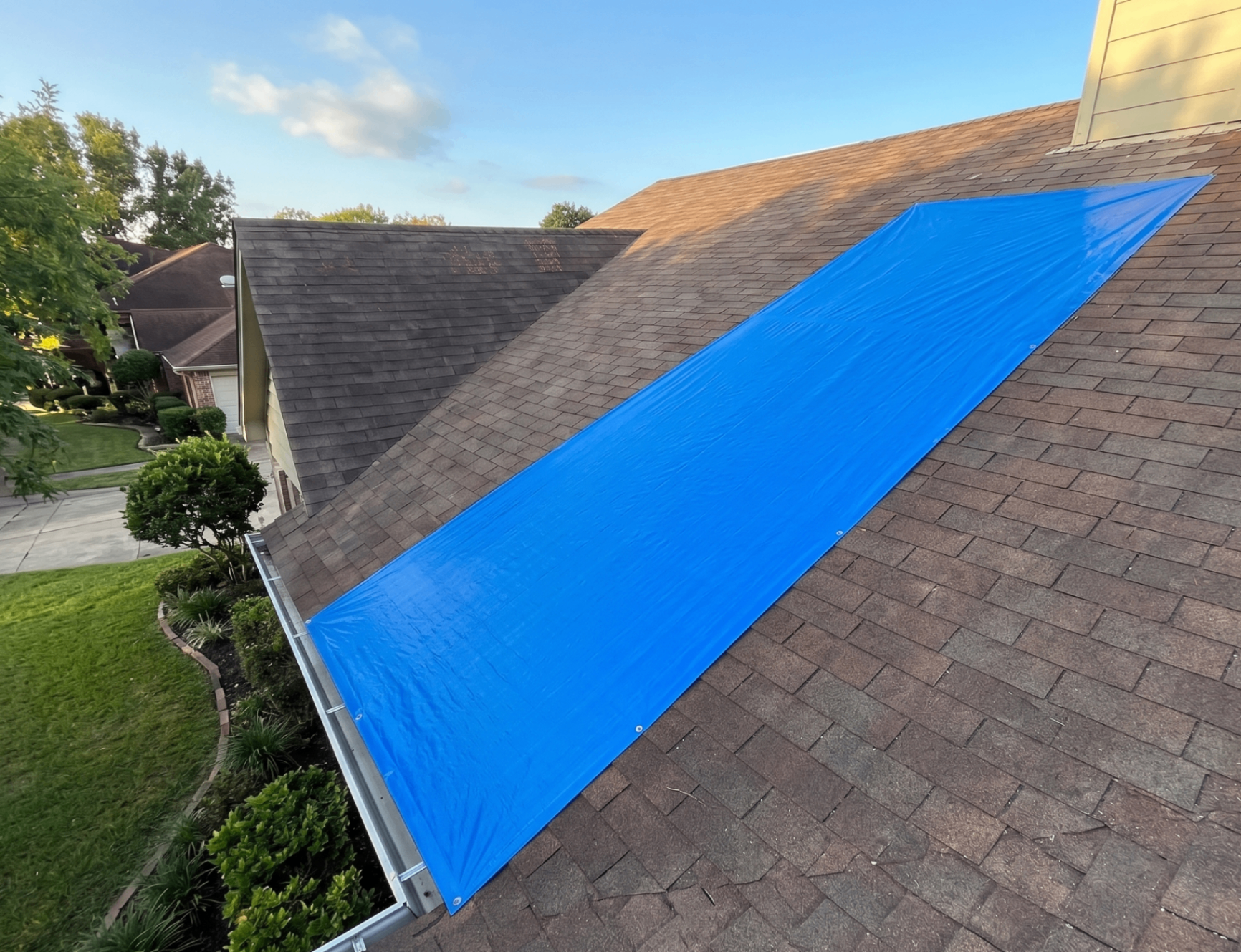 Tarp profesional anclado para proteger área dañada.